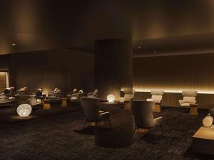 una sala de espera con sillas, mesas y luces en Grand Mercure Ise-shima Resort & Spa, en Shima