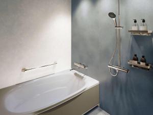 W łazience znajduje się biała wanna i prysznic. w obiekcie Grand Mercure Ise-shima Resort & Spa w mieście Shima
