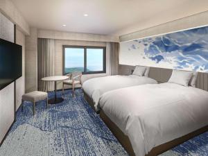 志摩的住宿－Grand Mercure Ise-shima Resort & Spa，酒店客房设有两张床和一张桌子。