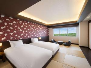 a hotel room with two beds and a window at Grand Mercure Okinawa Cape Zanpa Resort in Yomitan