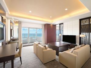 a living room with a table and a dining room at Grand Mercure Okinawa Cape Zanpa Resort in Yomitan