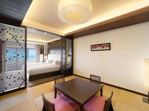 a room with a bed and a table and chairs at Grand Mercure Okinawa Cape Zanpa Resort in Yomitan