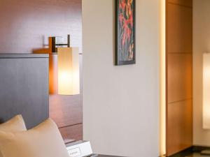 a room with a chair and a table with a lamp at Grand Mercure Okinawa Cape Zanpa Resort in Yomitan