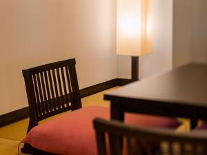 a room with a chair and a table with a lamp at Grand Mercure Okinawa Cape Zanpa Resort in Yomitan
