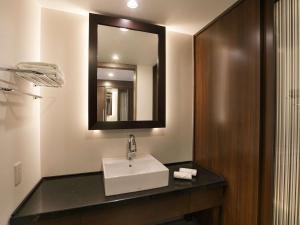 a bathroom with a sink and a mirror at Grand Mercure Okinawa Cape Zanpa Resort in Yomitan