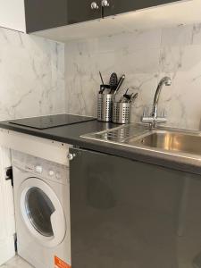 eine Küche mit einer Spüle und einer Waschmaschine in der Unterkunft Shoreditch & Liverpool Street Room B in London