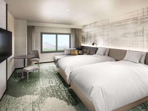 長浜市にあるグランドメルキュール琵琶湖リゾート & スパ のベッド2台と窓が備わるホテルルームです。