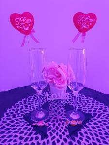 three wine glasses on a table with hearts and a rose at Il Mare di Roma Deluxe in Lido di Ostia