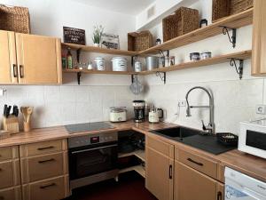 uma cozinha com armários de madeira, um lavatório e um micro-ondas em Ferienwohnung Nauen Familie Renner em Nauen