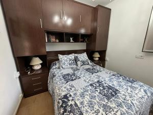 um quarto com uma cama com um edredão azul e branco em Casa Finca Patelo em Bergondo