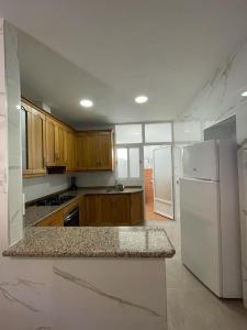 a kitchen with a white refrigerator and wooden cabinets at Casa Javi y Carmen in Coto Rios