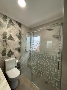 a bathroom with a toilet and a glass shower at Casa Javi y Carmen in Coto Rios
