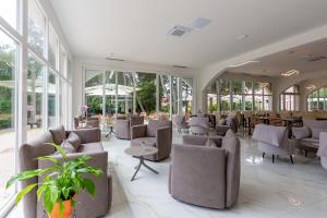 eine Lobby mit Stühlen, Tischen und Fenstern in der Unterkunft Hotel Emaus in Novigrad Istria