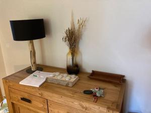 a wooden table with a lamp and a vase on it at Cohennoz Le Cernix - Appartement montagne avec piscine proche pistes in Cohennoz