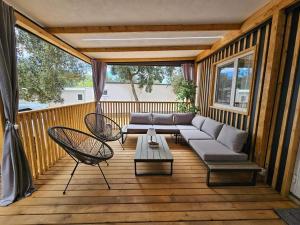 een veranda met een bank en stoelen op een terras bij Paradiso mobile home in Biograd na Moru