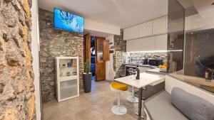 a kitchen with a white counter and a stone wall at Airam in Cefalù