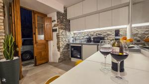 two glasses of wine sitting on a table in a kitchen at Airam in Cefalù +9 photos