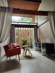a living room with a red couch and a tv at Pousada Rainha da Mata in Penedo