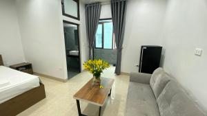 een woonkamer met een bank en een tafel met bloemen bij Era Apartment Tran Thai Tong in Hanoi