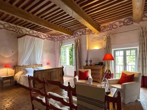 a bedroom with a bed and a table and chairs at LA PONCHE in Vacqueyras