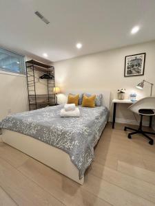 多倫多的住宿－BRAND NEW lower home with EXCLUSIVE Bathroom，一间卧室配有一张床、一张书桌和一张书桌