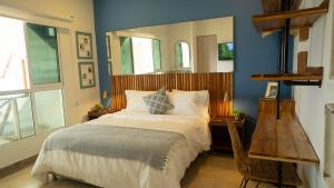 1 dormitorio con 1 cama con espejo en la pared en Casa Ramona : Suites Boutiques en Cartagena de Indias, en Cartagena de Indias