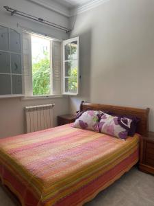 sypialnia z łóżkiem i 2 oknami w obiekcie Yassine's home w mieście Dżidżili