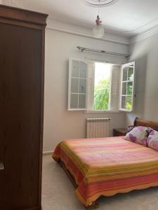 a bedroom with a bed and a window at Yassine's home in Jijel