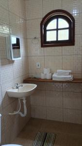 baño con lavabo y ventana en Pousada Casa da montanha en Casimiro de Abreu