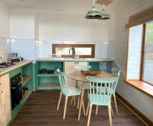 a kitchen with a table and chairs and a sink at Casa del mar Chiloé in Chonchi
