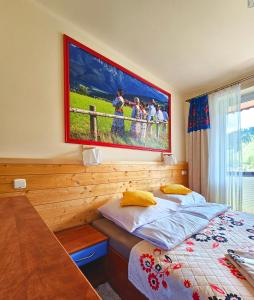 een slaapkamer met een bed en een groot schilderij aan de muur bij Willa Rosa in Szczyrk