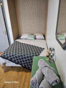 Un pequeño dormitorio con una cama y una mesa con toallas. en VILLA Zara, en Beauvais