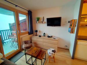 a living room with a tv and a table and a room at Avoriaz: appart rénové 4 pers, proche pistes, WiFi, casier à skis - FR-1-633-32 in Avoriaz +5 photos