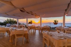 un ristorante con tavoli e sedie con vista sull'oceano di Terrazza Iride a Massa Lubrense