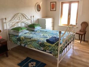 a bedroom with a white bed with green pillows at La Biste in Mirepoix