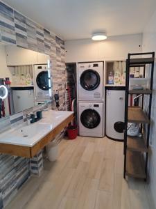 eine Waschküche mit zwei Waschmaschinen und einem Waschbecken in der Unterkunft Campagne Océan Le Gite in Montroy