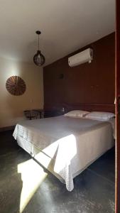 um quarto com uma grande cama branca num quarto em Espaco Morro do Frota em Pirenópolis