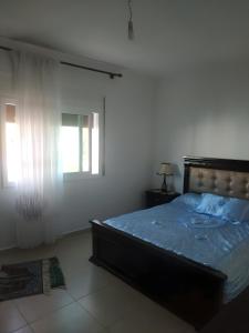 1 dormitorio con cama y ventana en Family Apartment By the Beach With a Pretty View, en Oued Laou