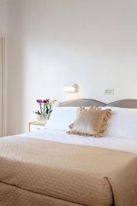 a bedroom with a white bed with a pillow on it at CASA GABRIELLA in Cattolica +39 photos