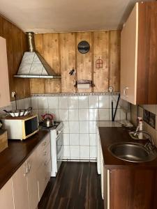 a small kitchen with a sink and a microwave at Mieszkanie Strajku Dokerów 2 lok 5 in Gdańsk
