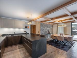une cuisine et une salle à manger avec une table et des chaises dans l'établissement Appartement neuf, ski-in/ski-out avec SPA et piscine à Courchevel 1850 - FR-1-564-105, à Courchevel