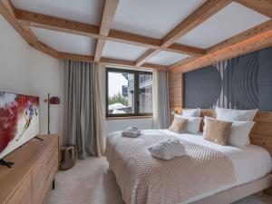 une chambre avec un grand lit et une grande fenêtre dans l'établissement Appartement neuf, ski-in/ski-out avec SPA et piscine à Courchevel 1850 - FR-1-564-105, à Courchevel 4 autres photos