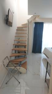 a set of stairs in a room with a chair at AIR-IN Rooms with magnificent views- Airport shuttle in Artemida