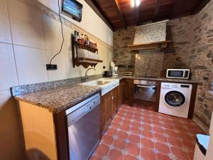 eine Küche mit einer Spüle und einer Waschmaschine in der Unterkunft Eira de Bergondo in Bergondo