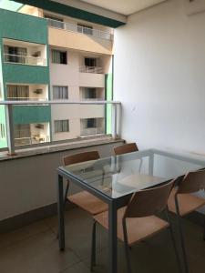 ein Glastisch und Stühle in einem Raum mit einem Gebäude in der Unterkunft Olímpia Park Resort in Olímpia