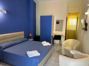 una camera blu con un letto e una sedia di Borgo San Cosmo Tropea a Brattirò