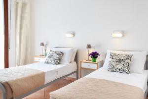 two beds in a room with white walls at CASA GABRIELLA in Cattolica
