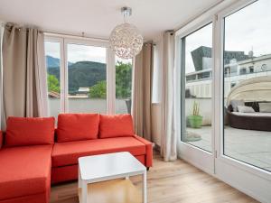a living room with a red couch and a large window at Gorgeous Apartment in Innsbruck near Ambras Castle in Innsbruck