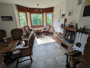 a living room with a fireplace and a table and chairs at Apartamenty SnowHouse in Duszniki Zdrój