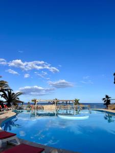 une grande piscine avec l'océan en arrière-plan dans l'établissement Village Vacances La Vallicella, à Poggio-Mezzana